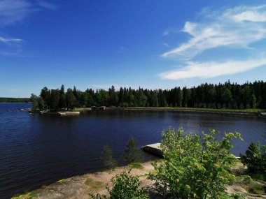 Vyborg şehrinin Monrepos Parkı 'ndaki Vyborg Körfezi' nin pitoresk sahilindeki gözlem güvertesinden mavi bulutlu bir gökyüzünün arka planına bakın..