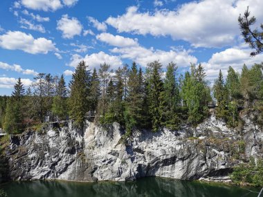 Güneşli bir yaz gününde Ruskeala Dağ Parkı 'ndaki Mermer Kanyon' un manzarası ve zümrüt suyu..