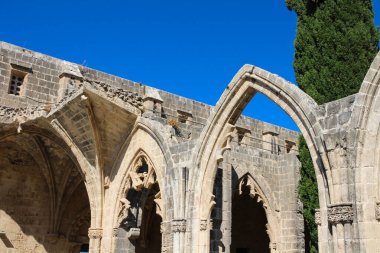 Bellapais Manastırı 'nın bir parçası, Beyaz Manastır, Güzel Dünya Manastırı. Mavi gökyüzüne karşı kemerler ve selvi.