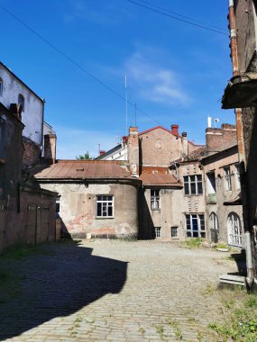 Güneşli bir yaz gününde Vyborg 'da, alçak katlı eski evleri olan kaldırım taşlarıyla kaplı bir avlu..