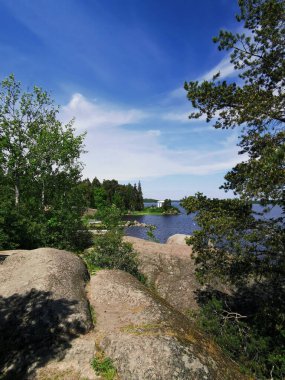 Vyborg şehrinin Monrepos Parkı 'ndaki Vyborg Körfezi' nin kıyısında duran Neptün Tapınağı 'nın görüntüsü bulutlu mavi gökyüzünün arka planına karşı..