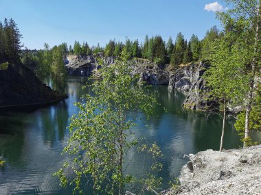 Ruskeala Dağ Parkı 'ndaki Mermer Kanyon' un zümrüt suyunun gözlem güvertesinden gökyüzünün yansıması ve bulutların berrak bir yaz gününde yansıması..