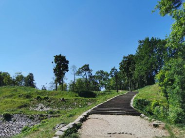Kronstadt şehrinin yaz bahçesinde bulutsuz bir gökyüzünün arka planında geniş bir taş merdiven.