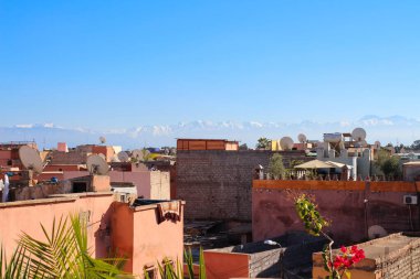 MARRAKECH.MOROCCO.Evlerin ve Atlas dağlarının çatısındaki Fas Riad 'dan görüntü.