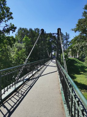  Kronstadt 'ta bir yaz günü mavi gökyüzüne karşı dar, asılmış, yayalara açılan bir Makarovsky Köprüsü..