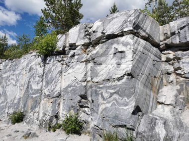 Güneşli bir yaz gününde Ruskeala Dağ Parkı 'nda pürüzsüz mermer parçalı İtalyan taş ocağı.