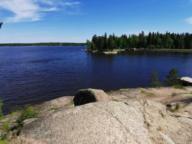 Vyborg şehrinin Monrepos Parkı 'ndaki Vyborg Körfezi' nin pitoresk sahilindeki gözlem güvertesinden mavi bulutlu bir gökyüzünün arka planına bakın..