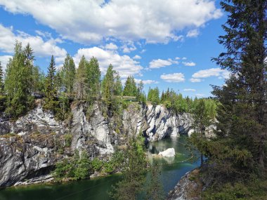 Güneşli bir yaz gününde Ruskeala Dağ Parkı 'ndaki Mermer Kanyon' un devasa taşları ve zümrüt suyu manzarası..