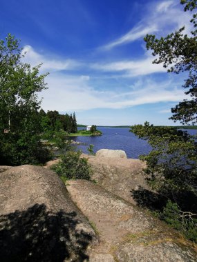 Vyborg şehrinin Monrepos Parkı 'ndaki Vyborg Körfezi' nin kıyısında duran Neptün Tapınağı 'nın görüntüsü bulutlu mavi gökyüzünün arka planına karşı..