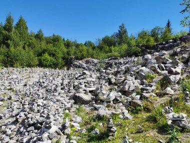 Dağın yamacında Ruskeala dağ parkında dilek tutarken insanlar tarafından inşa edilmiş bir sürü mermer piramitli beyaz dağ..