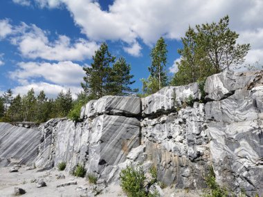 Güneşli bir yaz gününde Ruskeala Dağ Parkı 'nda pürüzsüz mermer parçalı İtalyan taş ocağı.