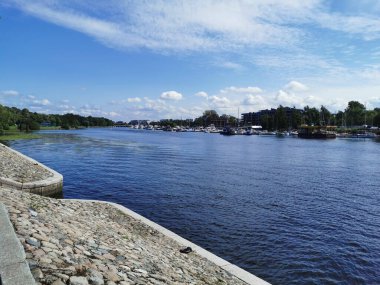 Krestovsky Adası açıklarında güneşli bir yaz gününde bulutlu mavi gökyüzüne karşı duran yatların taştan seti..