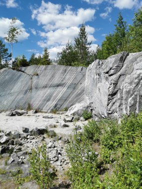 Güneşli bir yaz gününde Ruskeala Dağ Parkı 'nda pürüzsüz mermer parçalı İtalyan taş ocağı.