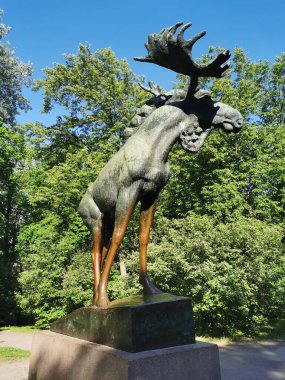 Mavi gökyüzüne karşı Vyborg şehrindeki Lenin Park 'ta granit bir heykel üzerinde bronz bir Moose heykeli..