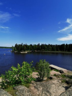 Vyborg şehrinin Monrepos Parkı 'ndaki Vyborg Körfezi' nin pitoresk sahilindeki gözlem güvertesinden mavi bulutlu bir gökyüzünün arka planına bakın..