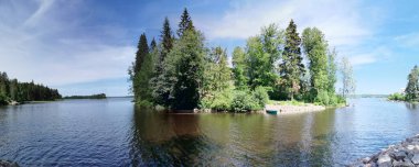 Vyborg Körfezi kıyısından adaya kadar uzanan manzaranın manzarası. Açık bir yaz gününde Vyborg şehrinin Monrepos kayalıklarında bir mağara ve bir şapel..