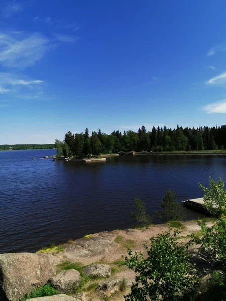 Vyborg şehrinin Monrepos Parkı 'ndaki Vyborg Körfezi' nin pitoresk sahilindeki gözlem güvertesinden mavi bulutlu bir gökyüzünün arka planına bakın..
