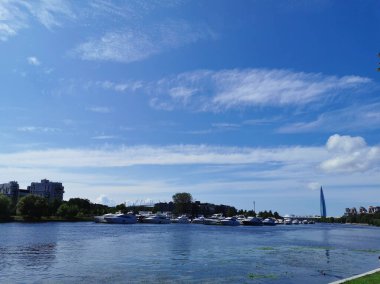 Krestovsky Adası kıyısı yakınındaki yat parkı güneşli bir yaz gününde bulutlu mavi gökyüzünün arka planına karşı.