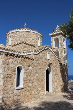 Protaras 'taki Aziz Elijah Kilisesi mavi gökyüzüne ve ağaca karşı. Kıbrıs.