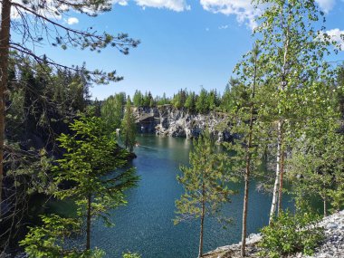 Bir yaz günü Ruskeala Dağ Parkı 'ndaki Mermer Kanyon' un turkuaz sularında yüzen kayalıkların, mağaraların ve teknelerin en üst görüntüsü..