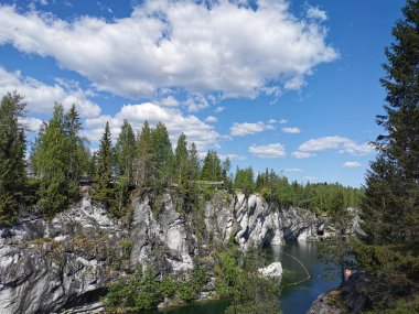 Bir yaz günü Ruskeala Dağ Parkı 'ndaki Mermer Kanyon' un turkuaz sularında yüzen kayalar, mağara ve tekneler görülüyor..