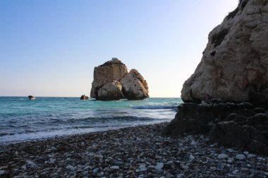 Afrodit 'in kayalık plajı ve efsanevi Afrodit Taşı mavi bulutsuz gökyüzüne karşı. Kıbrıs.