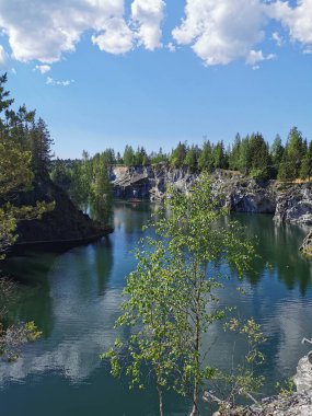 Ruskeala Dağ Parkı 'ndaki Mermer Kanyon' un zümrüt suyunun gözlem güvertesinden gökyüzünün yansıması ve bulutların berrak bir yaz gününde yansıması..