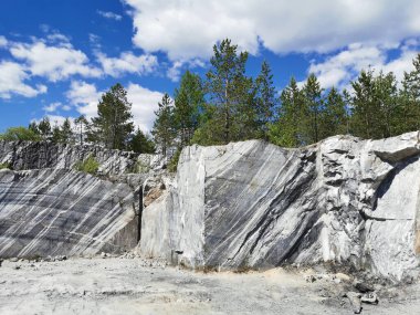 Güneşli bir yaz gününde Ruskeala Dağ Parkı 'ndaki mermer çıkarma sırasında pürüzsüz kesim ve kesikli İtalyan taş ocağı..