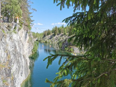 Bir yaz günü Ruskeala Dağ Parkı 'ndaki Mermer Kanyon' un turkuaz sularında yüzen kayalıkların, mağaraların ve teknelerin en üst görüntüsü..