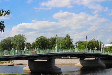 Nehrin üzerinde yeşil ve mavi bulutlu gökyüzünün arka planında ilginç ışıklar olan köprü..