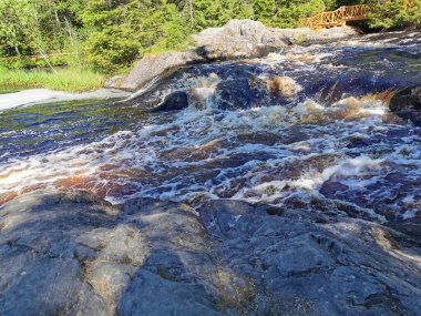 Karelia 'daki Tokhmayoki Nehri' ndeki kahverengi suyla kaynayan şelalenin manzarası ekolojik patikadan.