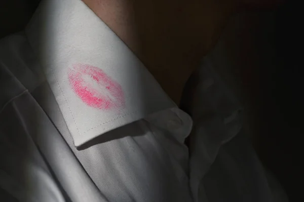 Lipstick marks on the collar of a men\'s white dress shirt