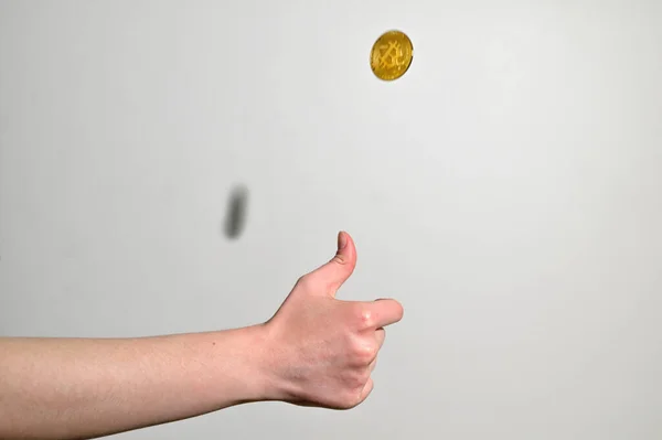 罗马尼亚加拉蒂 2021年4月9日人类在工作室里抛掷一枚金比特币 免版税图库图片