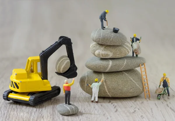 Pebbles stack och figuriner arbetstagare Royaltyfria Stockbilder