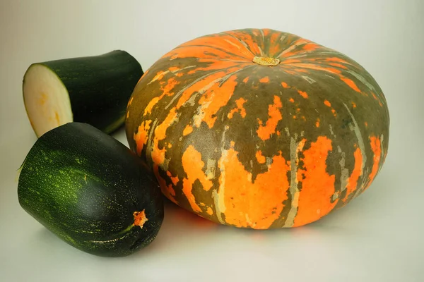 Calabaza naranja madura y calabacín verde maduro sobre un fondo blanco. —  Fotos de Stock