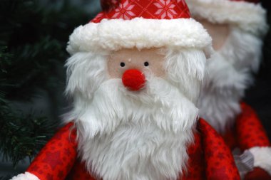 Noel ya da yeni yıl arkaplanı. Kırmızı elbiseli Noel Baba. Yumuşak Noel oyuncakları. 
