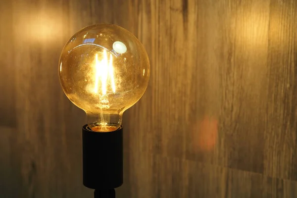 Lysande dekorativa lampa, varmt gult ljus på en trä bakgrund. En antik lampa. Antik dekorativ lampa. — Stockfoto