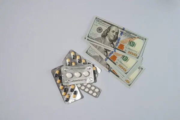 Billetes, dólares y medicinas. Concepto del coste de los medicamentos. — Foto de Stock