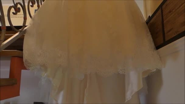 En vit bröllopsklänning hänger i brudens hus. — Stockvideo