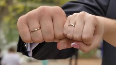 Gelin ve damadın elinde alyanslar.