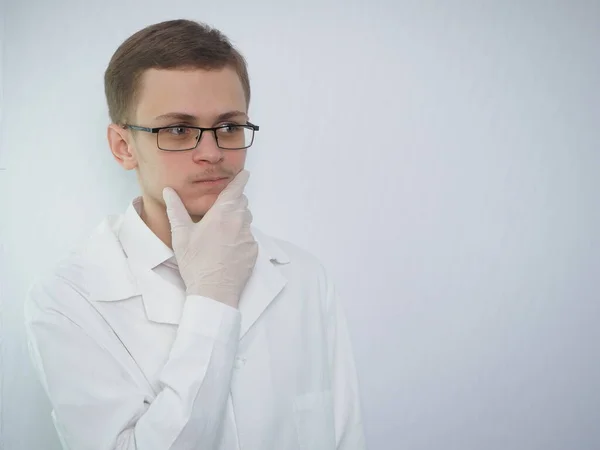 Портрет молодого європейця в білому медичному пальто. Молодий лікар у білому пальто. Медичний студент. — стокове фото