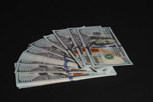 The American dollar. Paper bills of a hundred dollars on a black background. — Stock Photo, Image