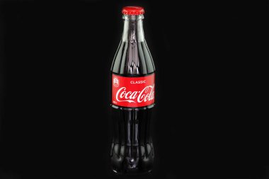 Coca Cola. Coca-Cola logosu olan cam şişe, yakın plan, siyah arka planda izole edilmiş. Düzenleyici kullanımı.