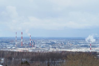 Kışın nehir kenarındaki büyük bir sanayi şehrinin panoramik manzarası.
