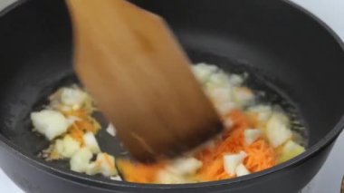 Sebzeleri kızartma tavasında kızart. Sebze yağında taze havuç ve soğandan geçer. Video.