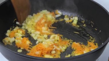 Sebzeleri kızartma tavasında kızart. Sebze yağında taze havuç ve soğandan geçer. Video.
