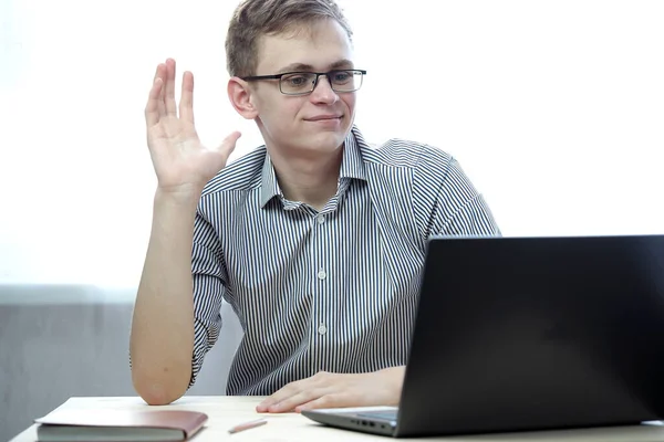 Genç bir kişinin bilgisayarında ya da internet eğitiminde uzaktan kumandalı bir işi var.