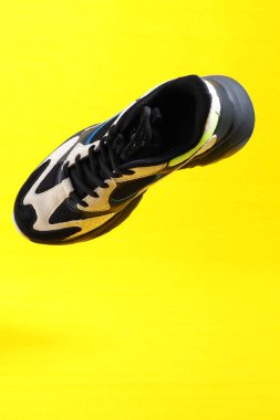 Sarı arka planda spor ayakkabılar. Şık spor ayakkabılar, yakın çekim, izole edilmiş, havalanma