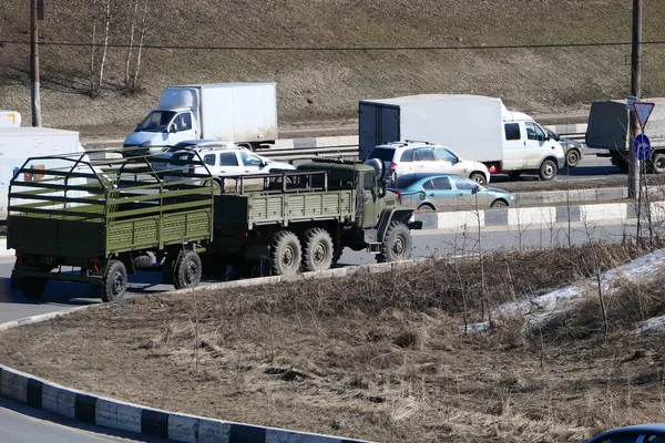 Transporte de pasajeros y un vehículo militar en la carretera de la ciudad. — Foto de Stock