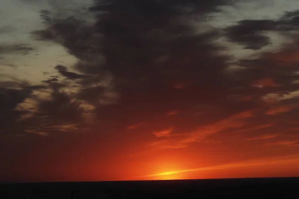 Het is een prachtige zonsondergang. Nacht hemel met wolken en de ondergaande zon aan de horizon. — Stockfoto